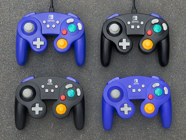 Purple and black GameCube style Nintendo Switch controllers on asphalt background