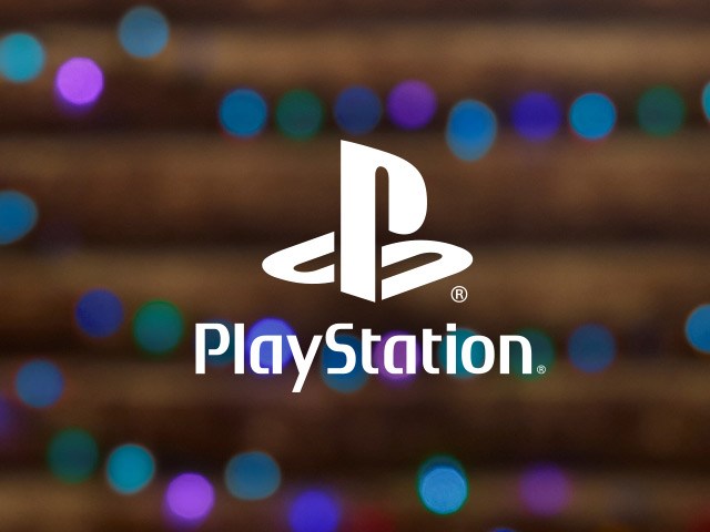 PlayStation logo on a background of warm glowy holiday lights