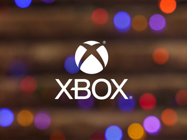 Xbox round logo on a background of warm glowy holiday lights