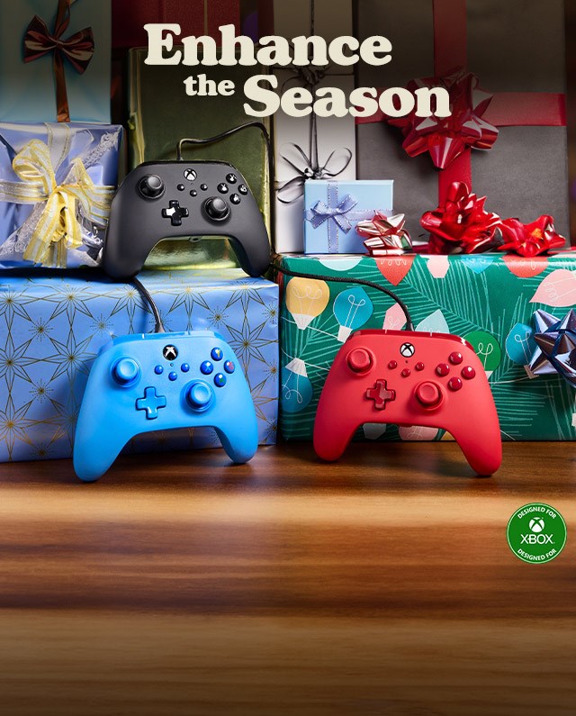 Colorful Xbox controllers laying among festive presents